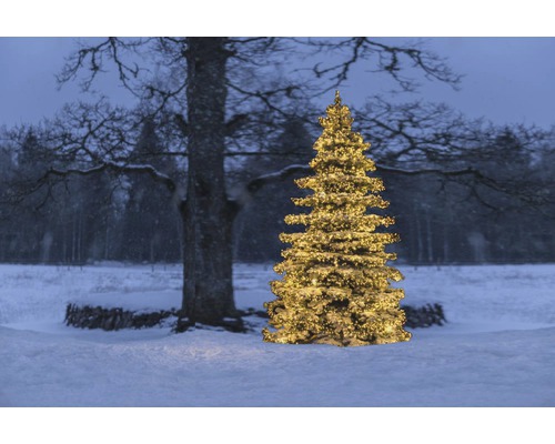 Belyst julgran i snöig utomhusmiljö