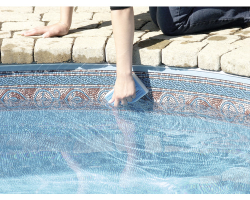 Person rengör en pool med en rengöringssvamp.