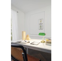 Ljust arbetsrum med skrivbord, skrivbordslampa, träfigurer och stol