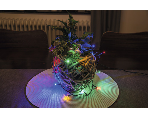 Dekorativ växtarrangemang med ljus i en flätad korg på ett bord