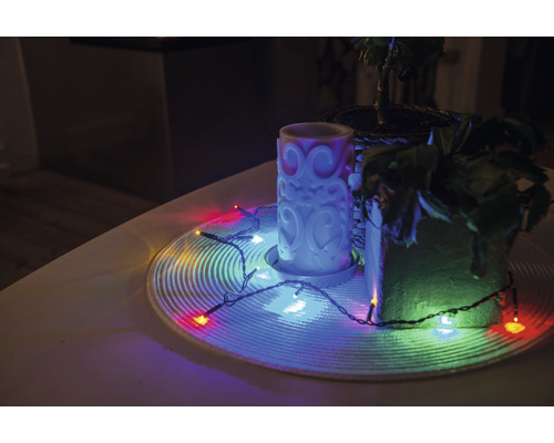 Dekoration med ljus, krukväxter och ljusslinga på ett bord