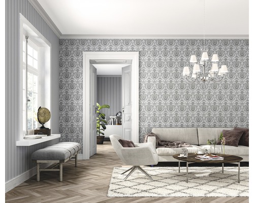 Ljust vardagsrum med tapet, soffa, fåtölj och trägolv