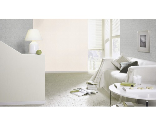 Vardagsrum med soffa, bord, lampa och mönstrad tapet