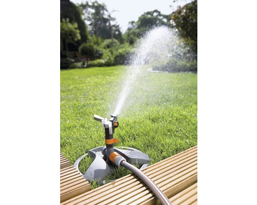 Grässpridare i trädgården som vattnar gräsmattan