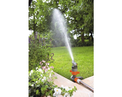 Trädgårdsbevattning med grässpridare i trädgården
