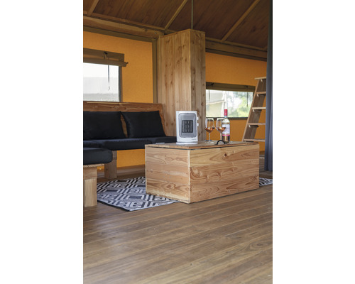 Interiör av ett tält med trämöbler, värmare och drycker.