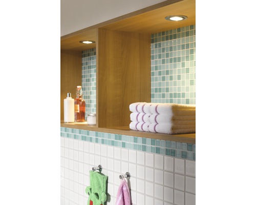 Badrumsvägg med hyllor, handdukar och kakel