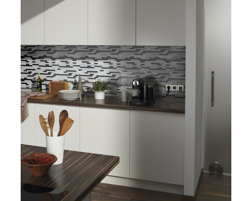 Köksscen med mosaikplattor, bänkskiva och köksredskap