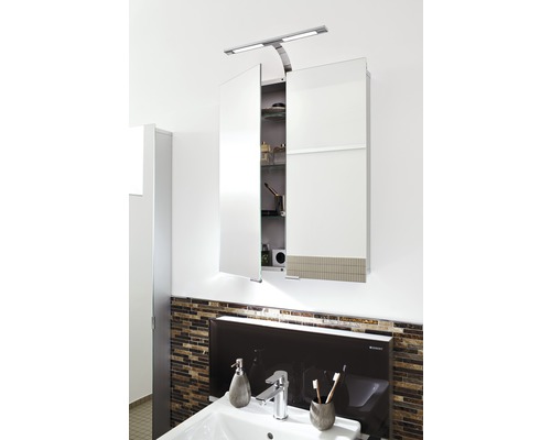 Spegelskåp med belysning ovanför ett handfat i badrummet.