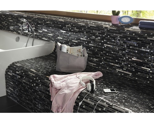 Badrum med mosaikplattor, badkar och tillbehör