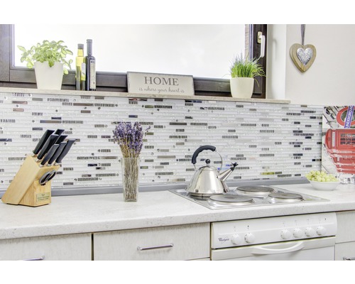 Köksscen med mosaikplattor, spishäll, vattenkokare och köksredskap