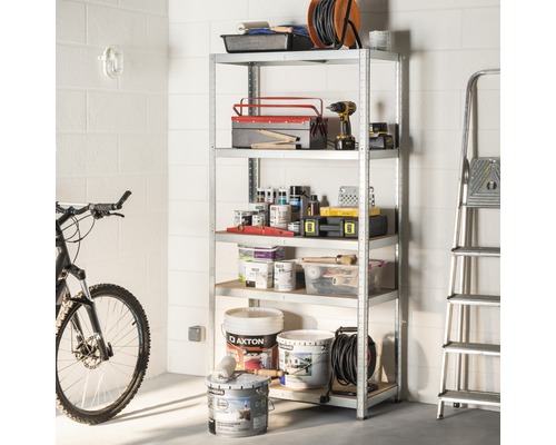 Hylla med verktyg, färgburkar och en stege i ett förrådsutrymme