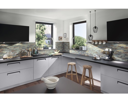 Ljust kök med grå skåp, bänkskivor och fönsterutsikt