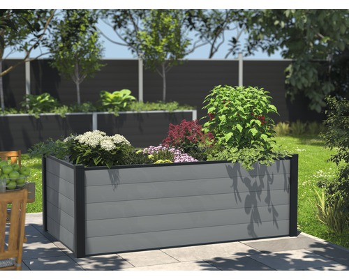 Hög rabatt av plast med växter i trädgården.