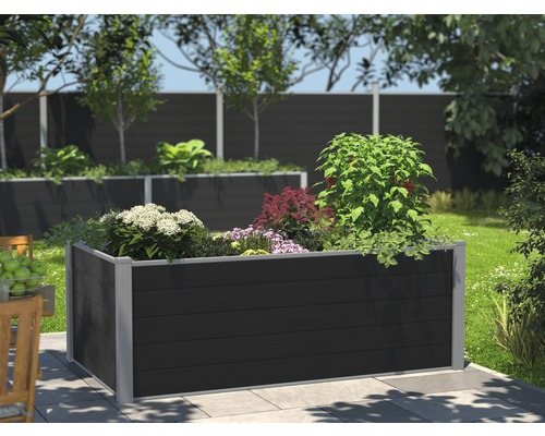 Upphöjd planteringslåda i plast med olika växter i trädgården