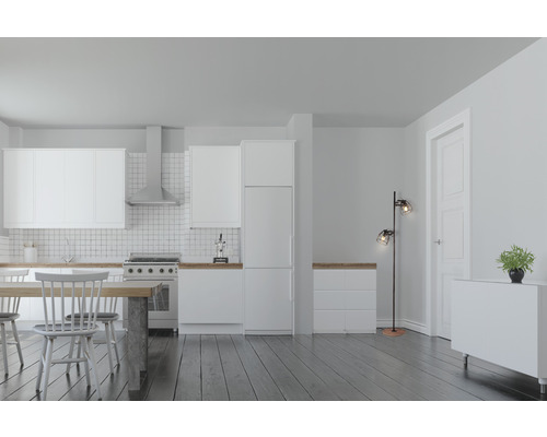 Ljust kök med vita skåp, matbord och golvlampa