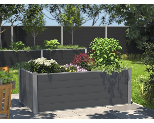 Upphöjd bädd av träkomposit med växter i trädgården