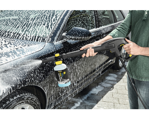 En person rengör en bil med en Kärcher högtryckstvätt och rengöringsmedel.
