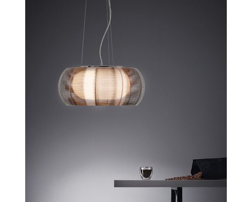 Hänglampa med trådnätskärm ovanför ett bord