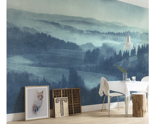 Vardagsrum med fototapet av ett bergslandskap, matbord och dekoration