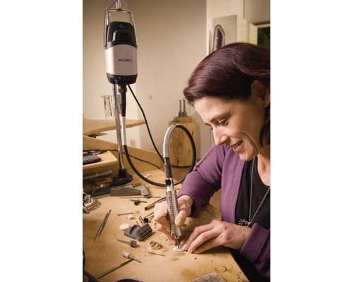 Kvinna arbetar med Dremel multifunktionsverktyg vid ett bord