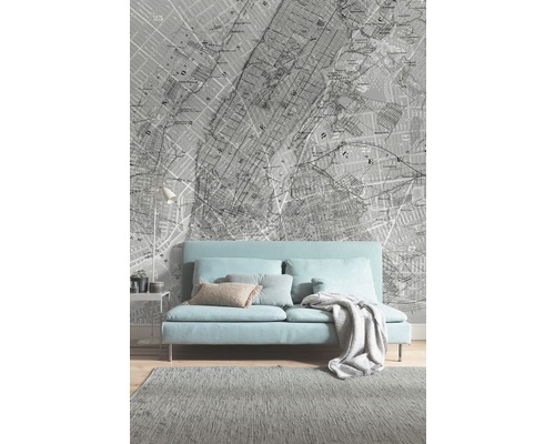 Vardagsrum med soffa, matta och tapet med stadsplansmönster