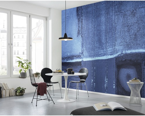 Ljust rum med abstrakt väggmålning, matbord och stolar