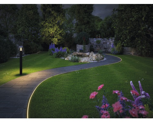 Trädgård med upplyst gångväg, trädgårdslampa, fontän och sittgrupp