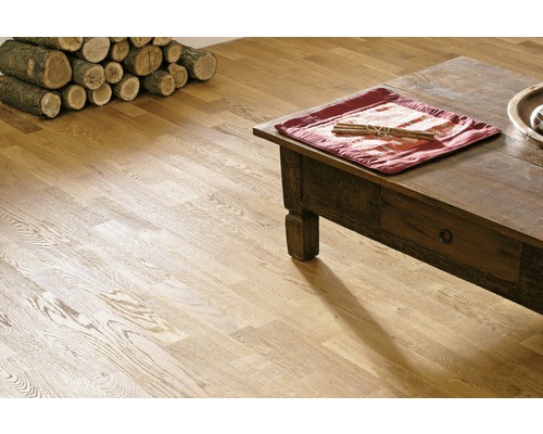 Interiör med trägolv, soffbord och vedstapel