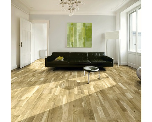 Vardagsrum med trägolv, soffa och konstverk