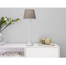 Dekorativ bordslampa på ett vitt skåp med dekoration