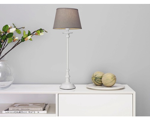 Dekorativ bordslampa på ett vitt skåp med dekoration