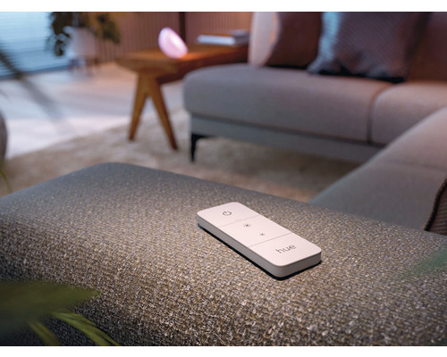 Philips Hue fjärrkontroll på en pall i ett vardagsrum
