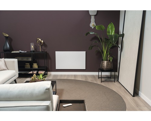 Vardagsrum med soffa, bord, krukväxt och radiator