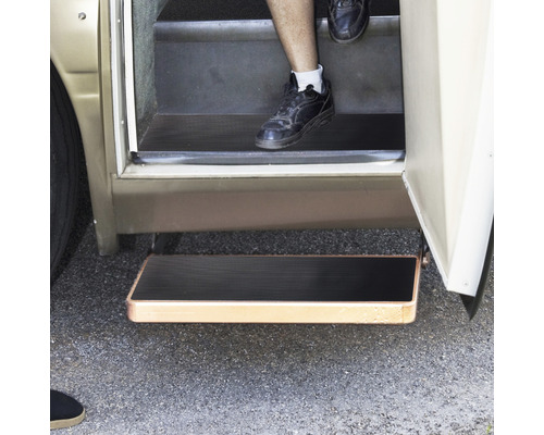 Utdragbart fotsteg på en husbil med en person som använder trappstegen.