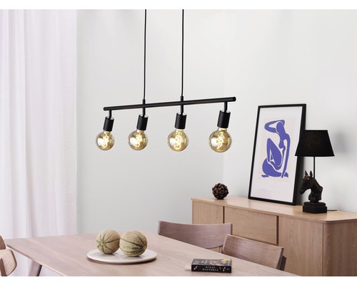 Matbordscen med en svart taklampa med fyra lampor ovanför bordet