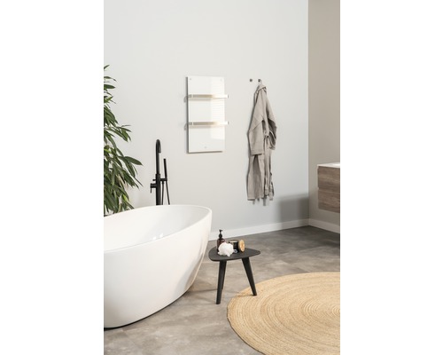 Modernt badrum med fristående badkar, handdukstork och dekorationer