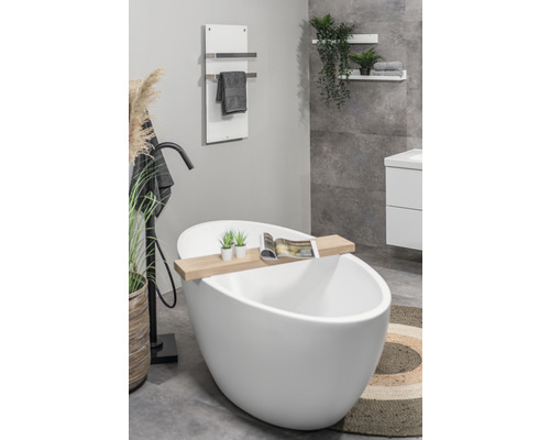 Badrum med fristående badkar, handdukstork och dekorativa element för en avkopplande atmosfär