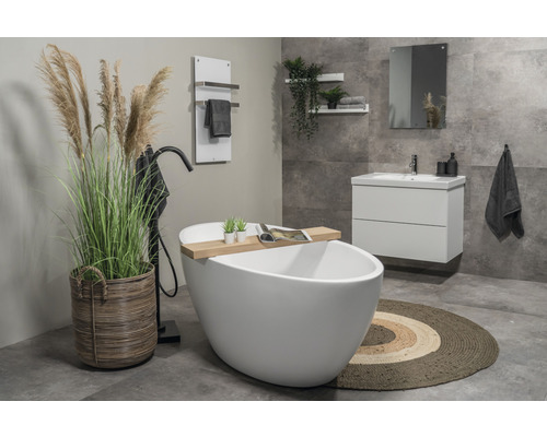 Badrum med fristående badkar, tvättställsskåp, spegel, handdukstork och dekoration