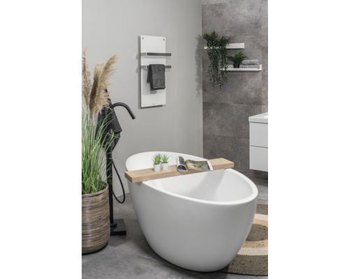 Modernt badrum med fristående badkar, handdukstork och dekorativa element för en ljus och organiserad atmosfär