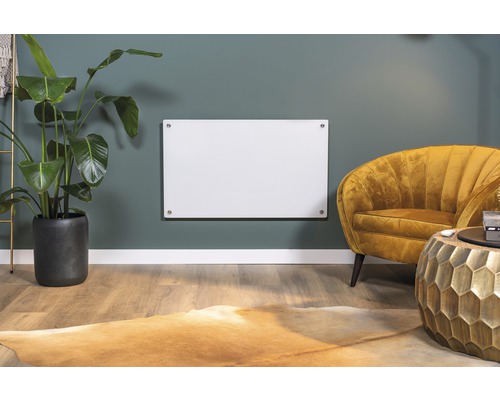 Vardagsrum med infraröd värmare på väggen, fåtölj, växt och matta