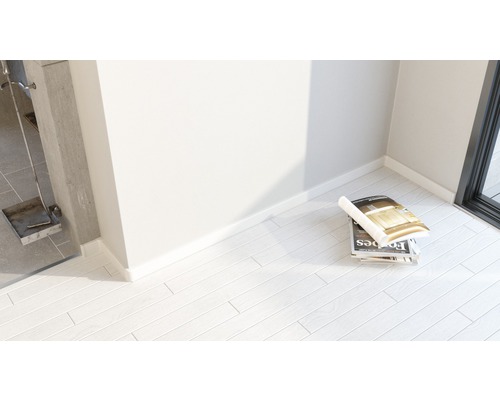 Ljust rum med tidningar på laminatgolv och eldstadsredskap.