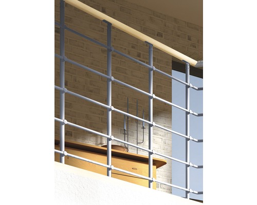 Metallräcke med träräcke framför en tegelvägg