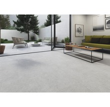 Ljust vardagsrum med klinkergolv, soffa och tillgång till trädgården