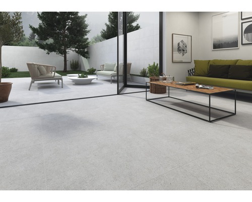 Ljust vardagsrum med klinkergolv, soffa och tillgång till trädgården