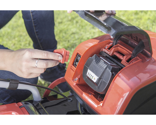 Sätta i batteriet i en gräsklippare