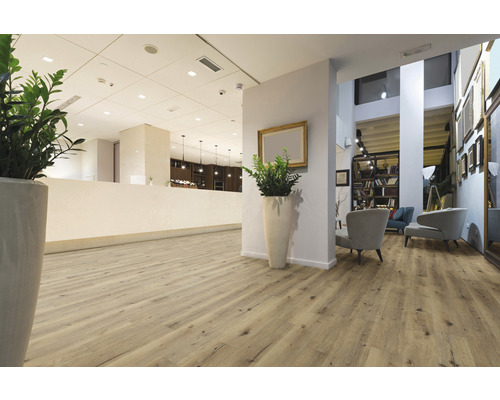 Ljus mottagningsyta med trägolv, växter och sittplatser.