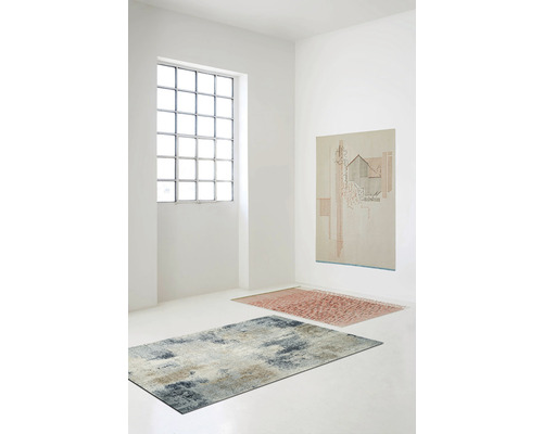 Ljust rum med två mattor och en tavla på väggen.
