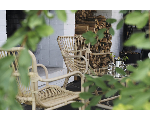 Uteplats med rottingmöbler och vedförvaring