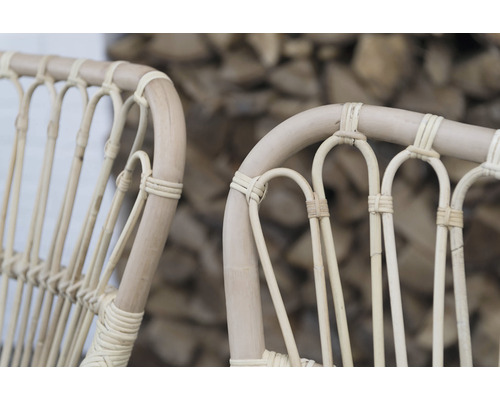 Närbild av två ljusa trädgårdsstolar i rotting